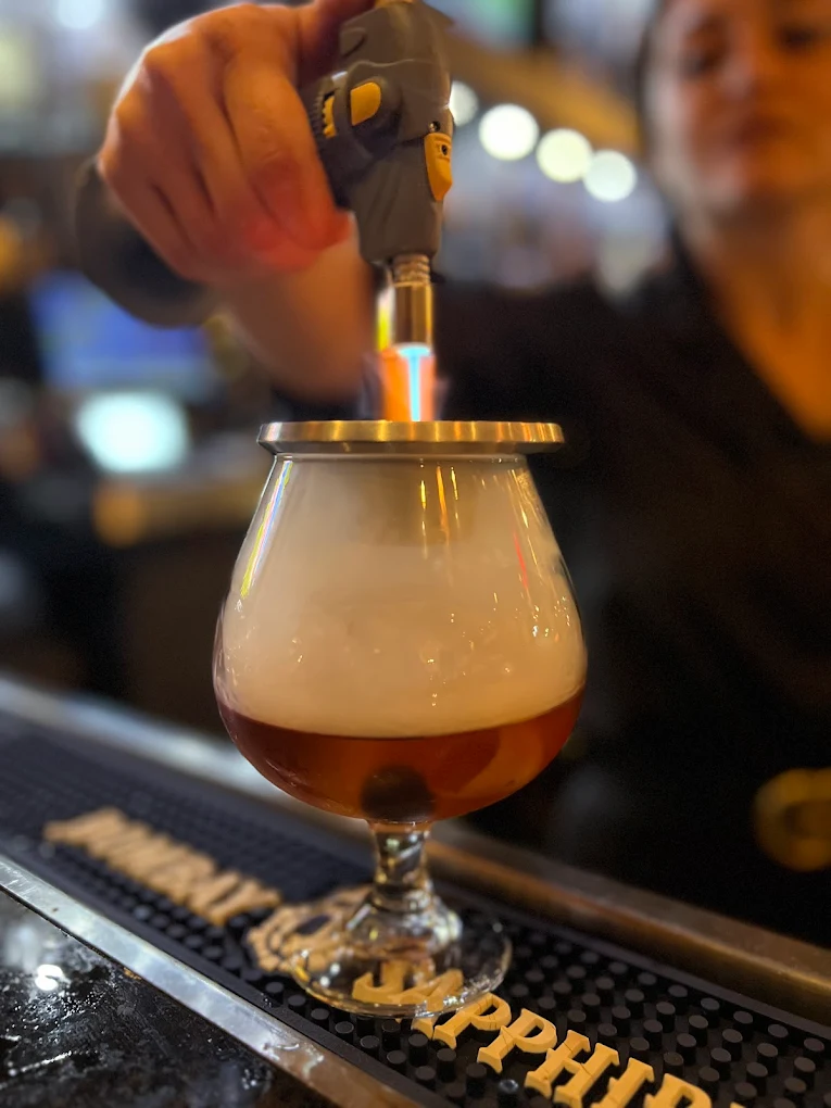 Craft cocktail being torched at Vincenzo bar after work happy hour Orlando