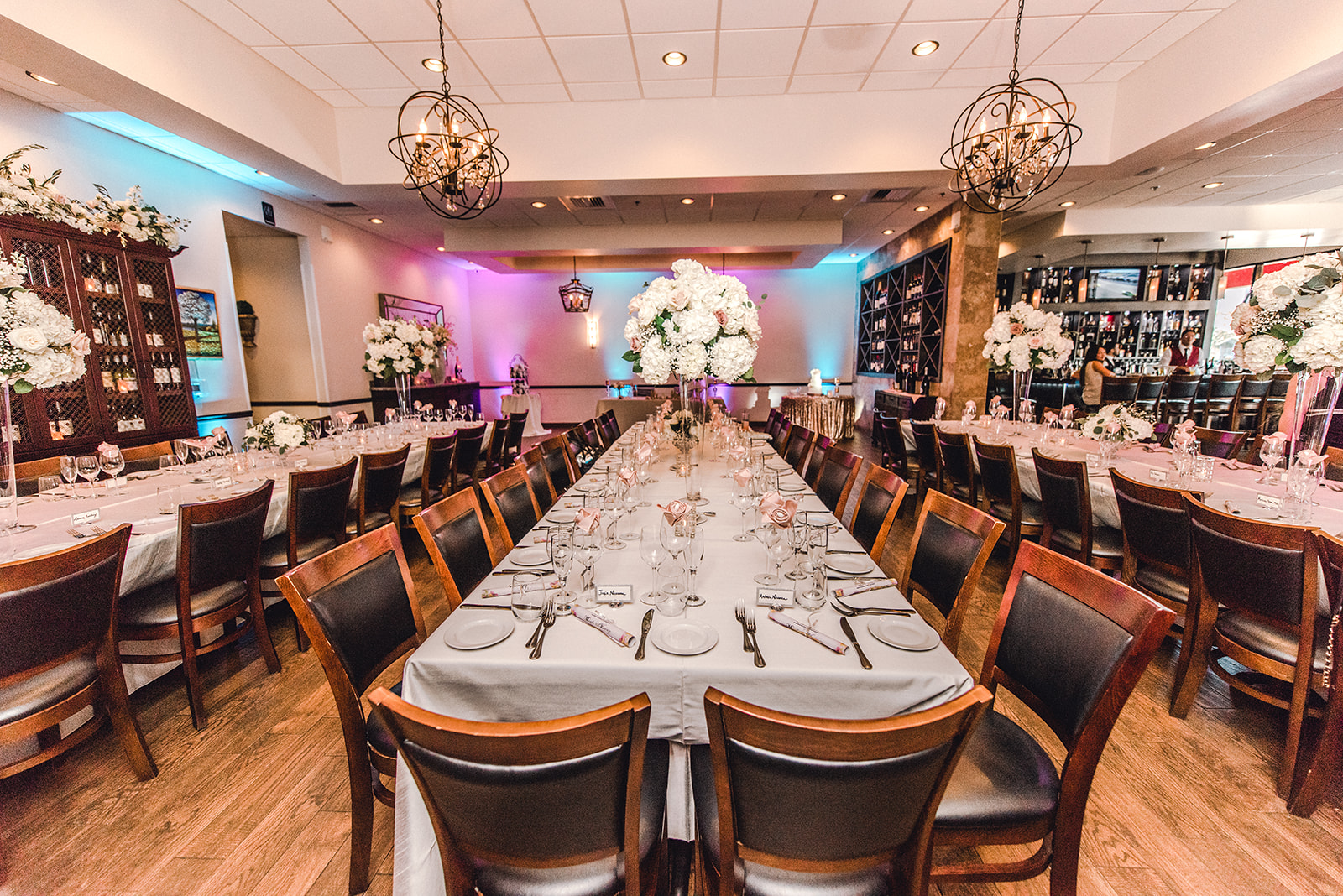 Rehearsal dinner setup at Vincenzo with flowers and uplighting
