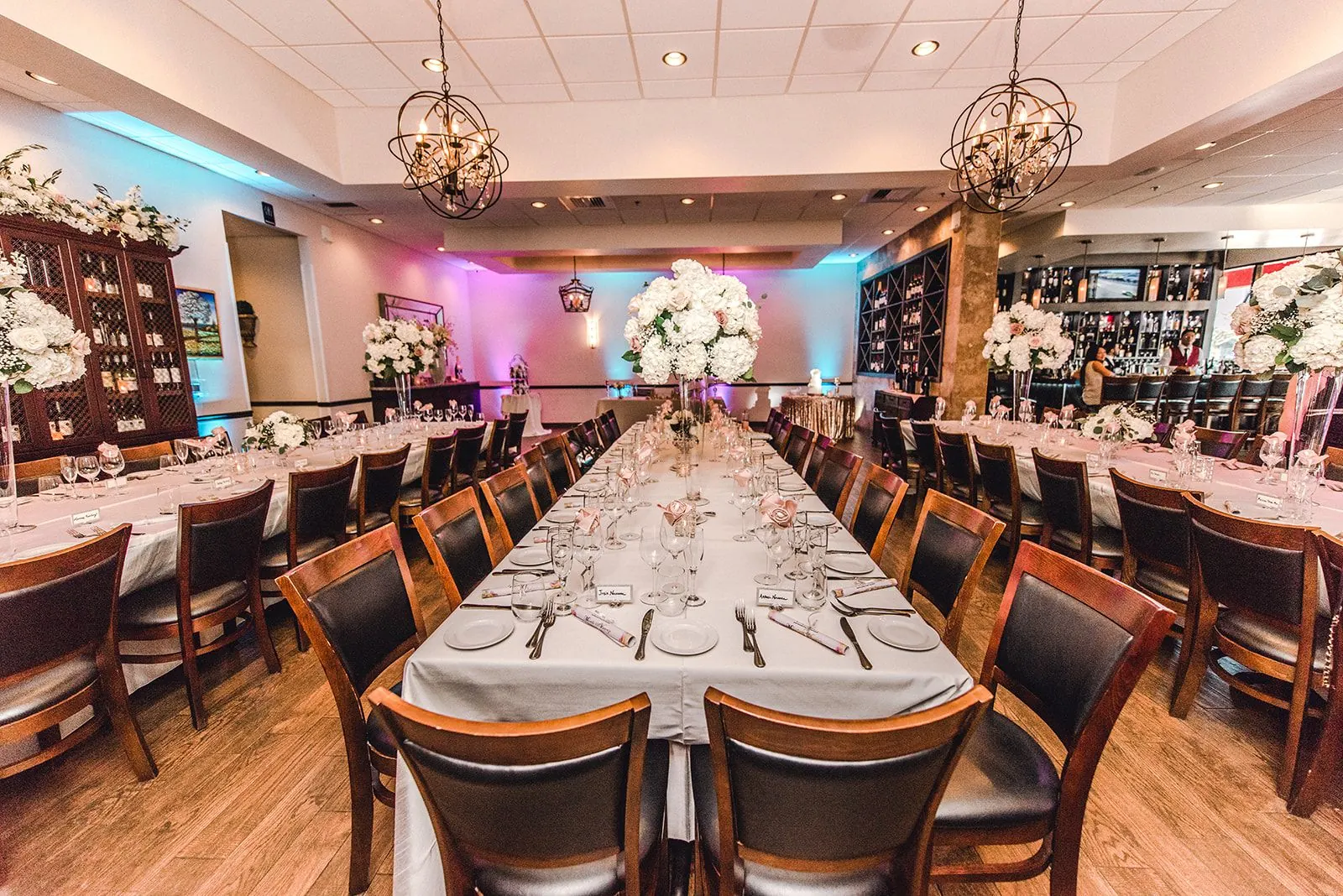 Rehearsal dinner setup at Vincenzo with flowers and uplighting